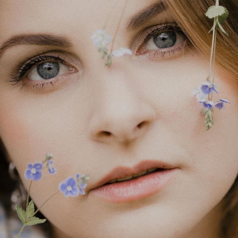 Woman with a calm and focused gaze in a serene environment.